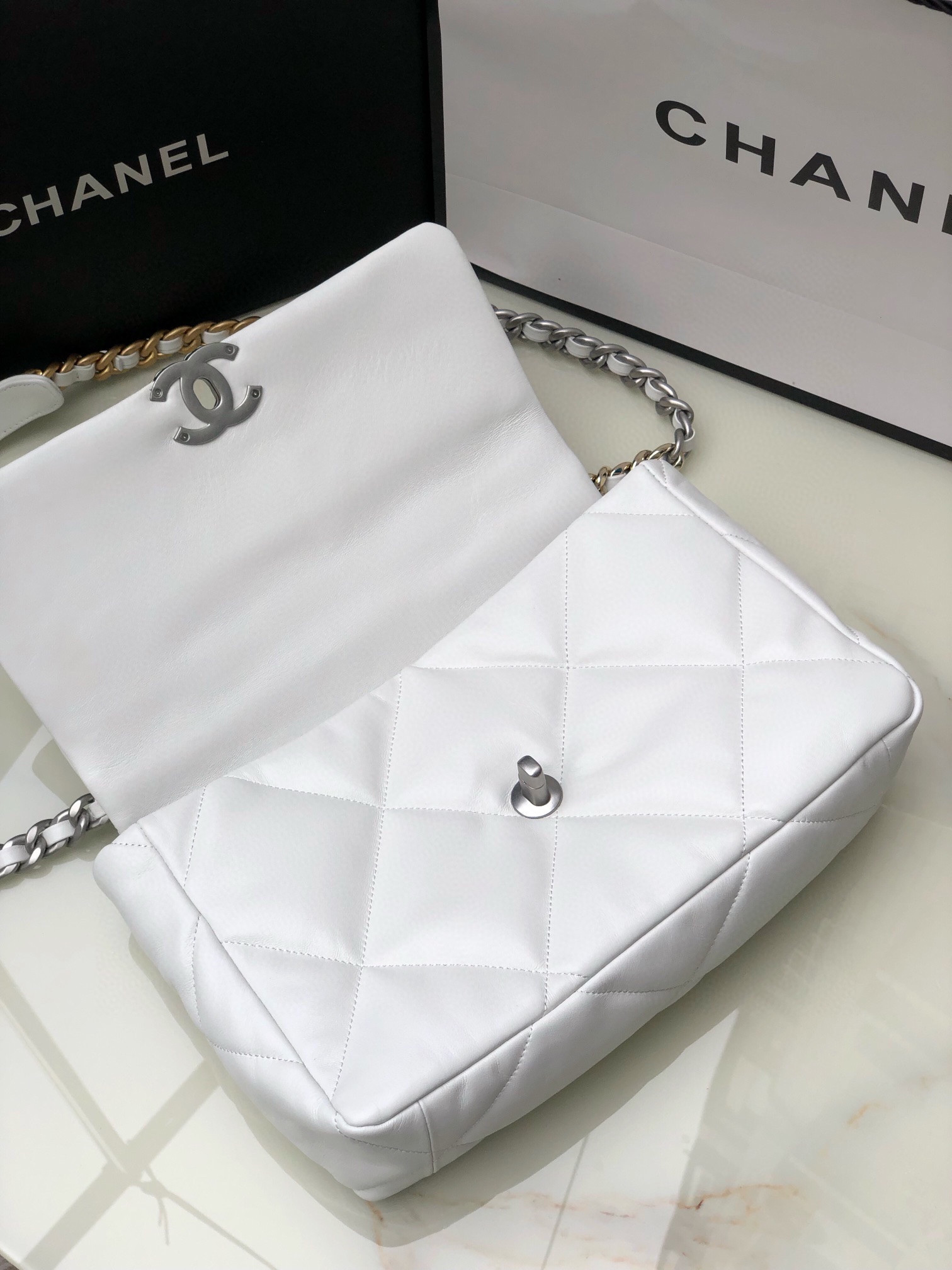 Ch*el 19 large handbag shiny leather, gold-tone, silver-tone & ruthenium-finish metal white 7.8 × 11.7 × 3.9 in